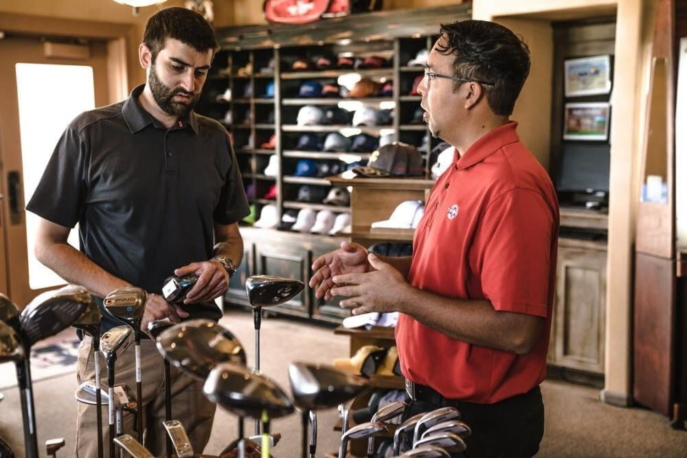 Two men speaking in a golf pro shop
